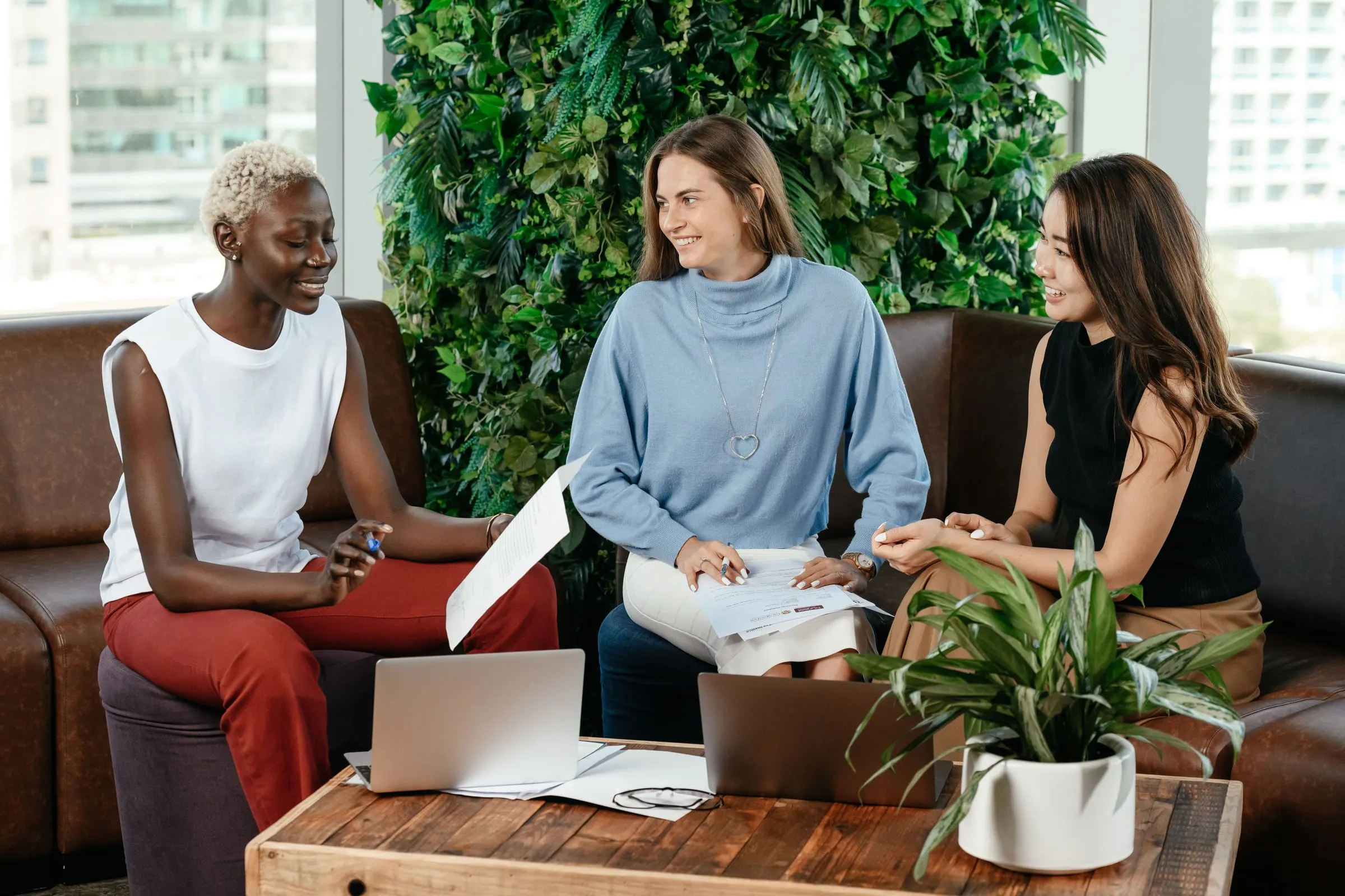 Three colleagues talking together during a relaxed team meeting